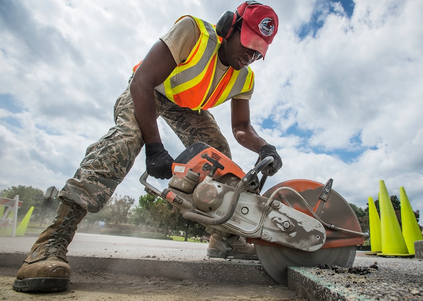 Senior Airman Kadeem Trammell, 560th Red Horse Squadron horizontal construction worker, cuts through asphalt using a K-12 saw during a re-pavement job Sept. 10, 2014, at Joint Base Charleston, S.C. Red Horse Airmen work with 628th Civil Engineer Squadron Airmen throughout the year to assist with jobs around the base as well as to complete upgrade training for deployments. (U.S. Air Force photo/ Senior Airman Dennis Sloan)