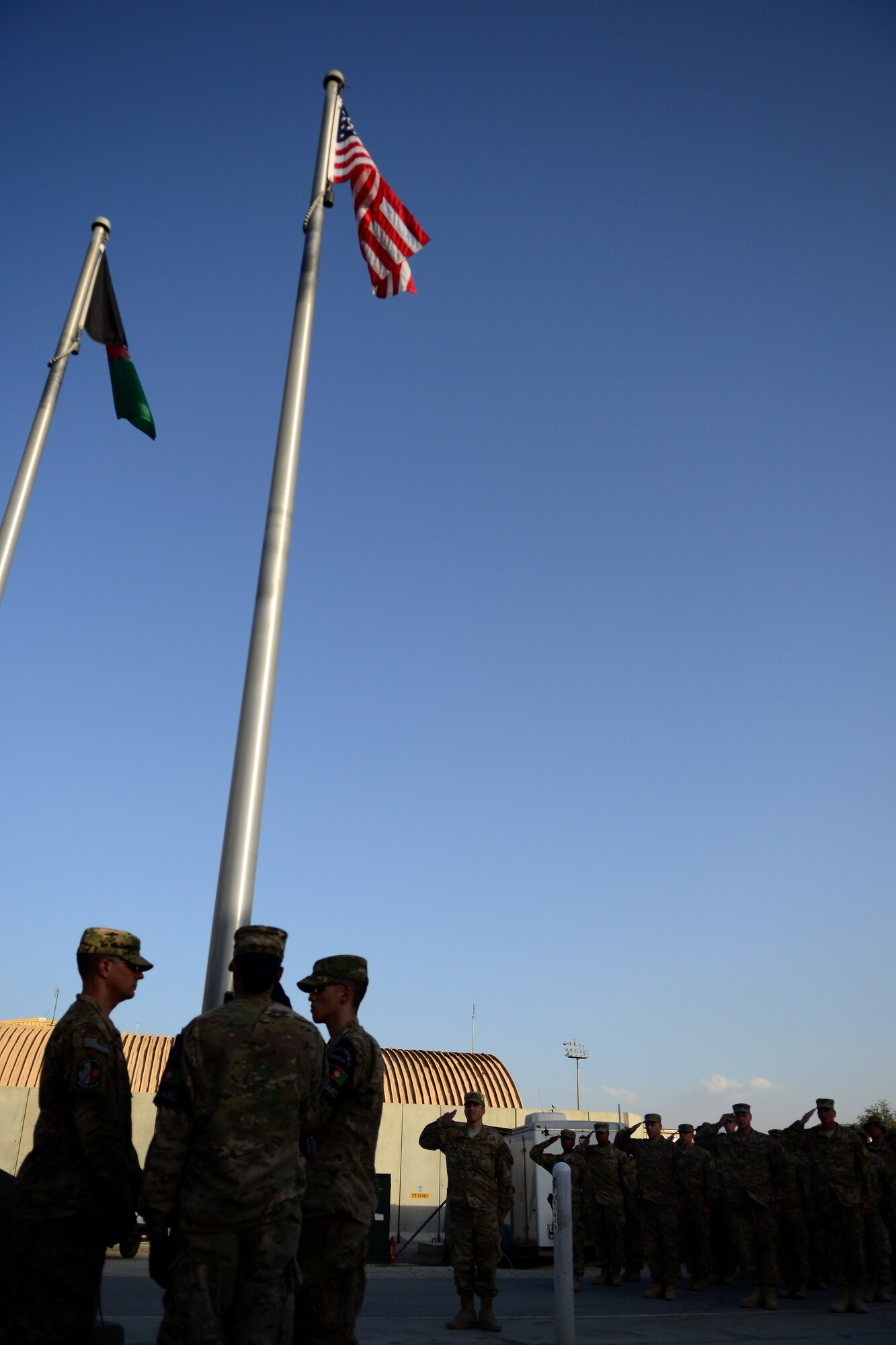 U.S. Air Force honor guard Airmen assigned to the 455th Air Expeditionary Wing raise a U.S. flag during a retreat ceremony at Bagram Airfield, Afghanistan Sept. 11, 2014.  Airmen participated in a Patriot's Day Retreat and reenlistment ceremony Sept. 11, 2014.  Patriot's Day is an annual observance to remember those who were injured or died during the attacks on Sept. 11, 2001. (U.S. Air Force photo by Staff Sgt. Evelyn Chavez/Released)