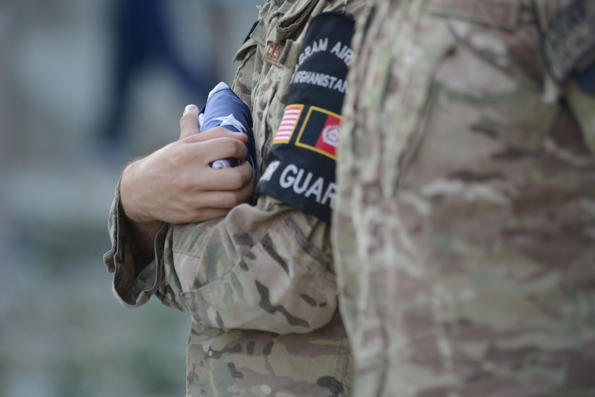 A member of the Bagram Airfield honor guard clutches the American Flag tightly to his chest at the conclusion of a retreat ceremony officiated by U.S. Air Force Brig. Gen. Mark D. Kelly, 455th Air Expeditionary Wing commander, at Camp Cunningham, Bagram Airfield, Afghanistan, Sept. 11, 2014. More than 200 Airmen attended the retreat and reenlistment ceremonies commemorating Patriot’s Day. (U.S.Air Force photo by Master Sgt. Cohen Young/Released)