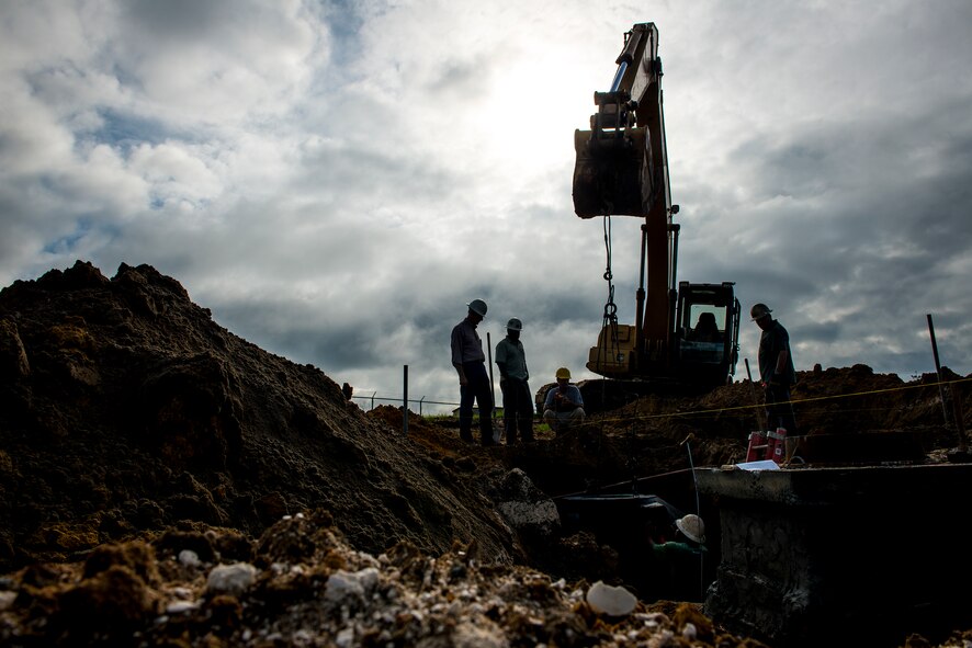 Construction workers use a backhoe to install drainage pipes Sept. 9, 2014, at Moody Air Force Base, Ga. In addition to repairing roads, the road pavement repair project will add storm drains and a parking lot off of Savannah Street. (U.S. Air Force photo by Airman 1st Class Ryan Callaghan/Released)