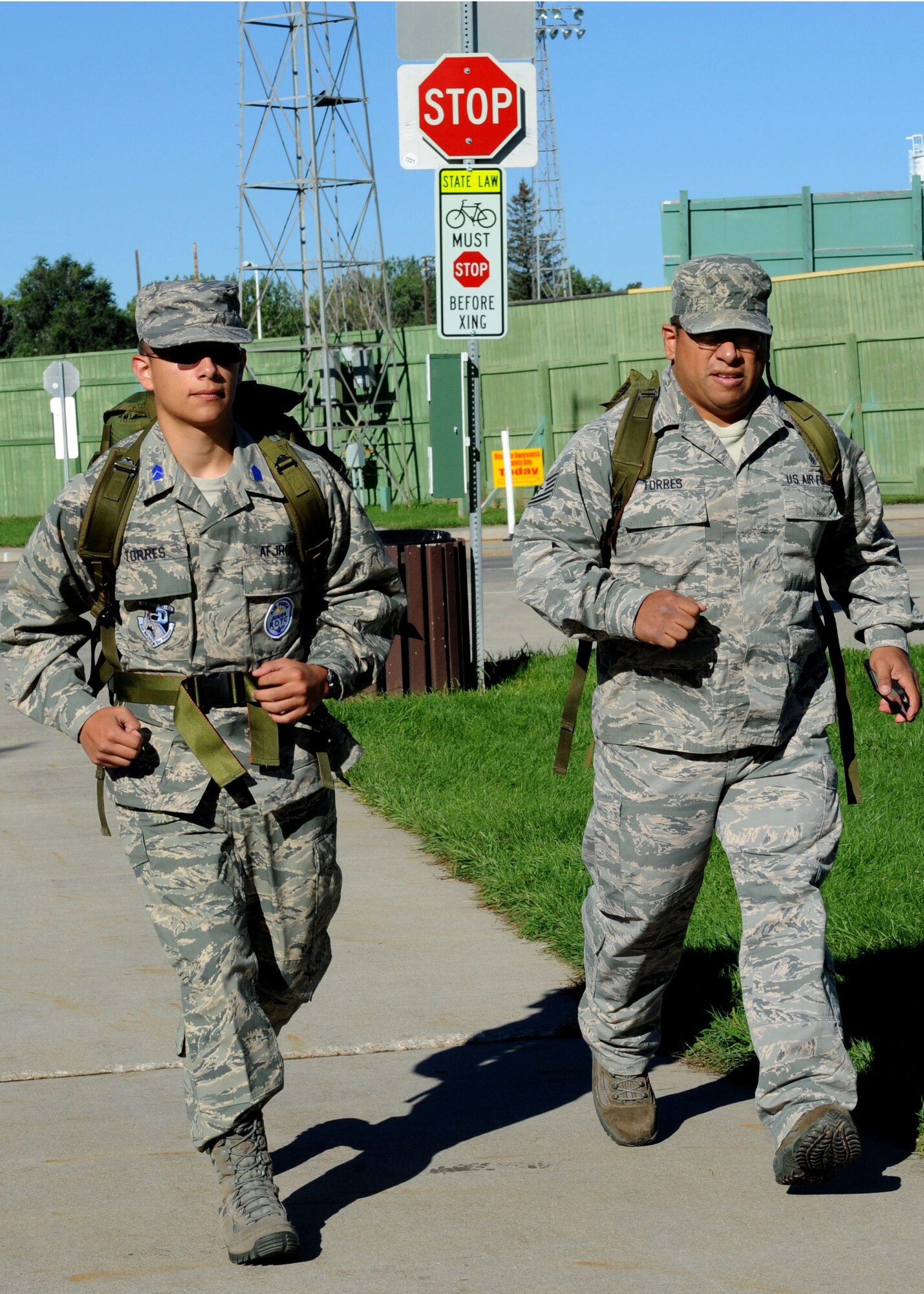 Cadet 2nd Lt. Jaime Torres, Air Force Junior Reserve Officer Training Corps, (left), joins his father, Tech. Sgt. Jaime Torres, 28th Medical Support Squadron medical logistics flight chief, during the 28th Security Forces Squadron 9/11 Ruck March at Floyd Fitzgerald Field, Rapid City, S.D., Sept. 6, 2014. The Torres men were two of more than 30 servicemembers and civilians who participated in the annual event, a 9.11 mile march to honor those who have made the ultimate sacrifice since Sept. 11. (U.S. Air Force photo by Senior Airman Hailey R. Staker/Released)