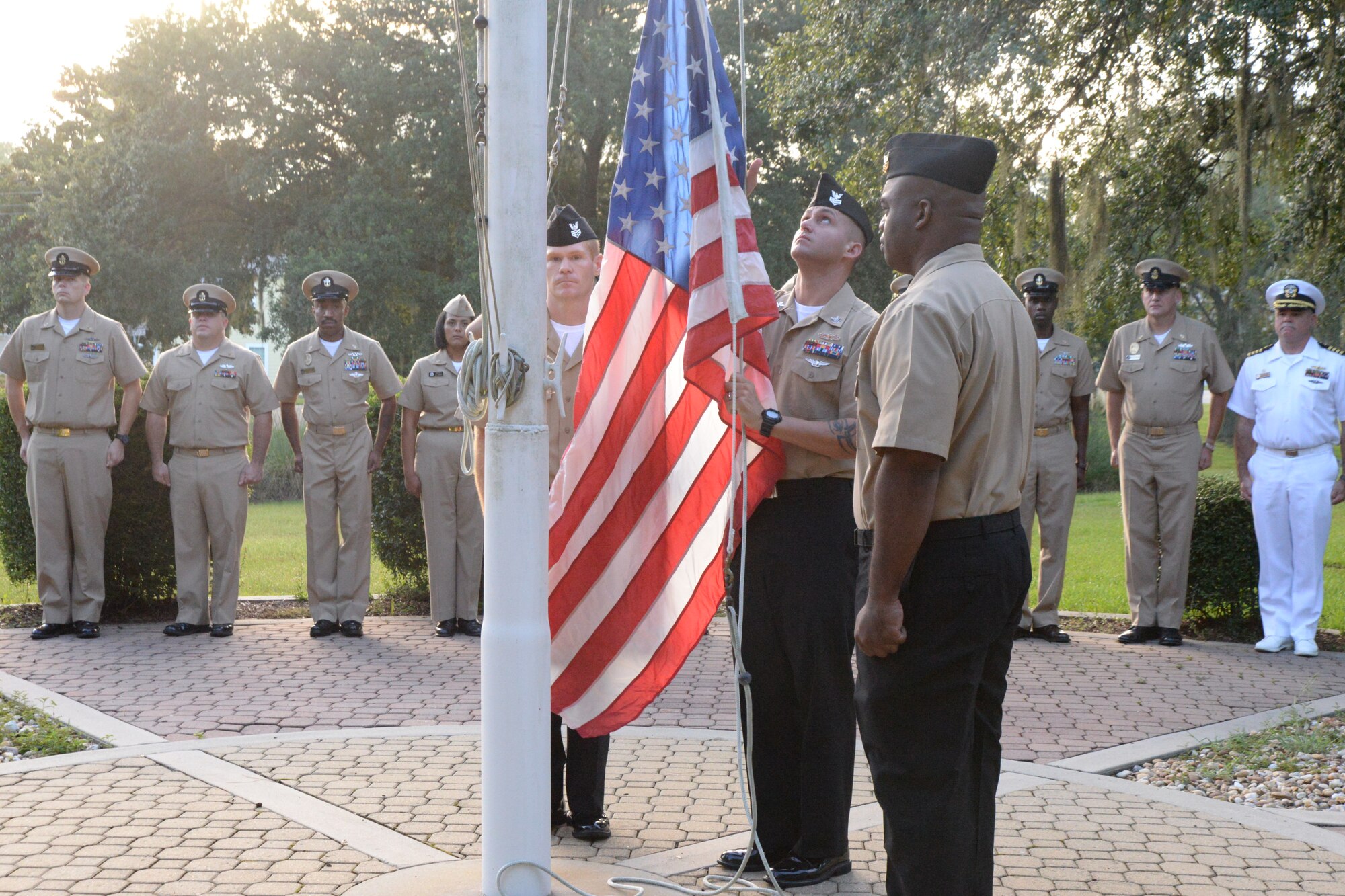 (Left to right) Chief Petty Officer Selectees Brad Carmen, Ryan Kinder and Terence Harmon, raise the colors Sept. 11, 2014, in front of the Naval Support Activity
headquarters on Joint Base Charleston, S.C., while members of the LowCountry
Chief Petty Officers Association and Capt. Timothy Sparks NSA commanding
officer (right) stand at attention. The selectees conducted the flag raising
ceremony in remembrance of the events of 9/11, and concluded with each
person in attendance telling their story of where they were on that day.
(U.S. Air Force photo/Eric Sesit)
