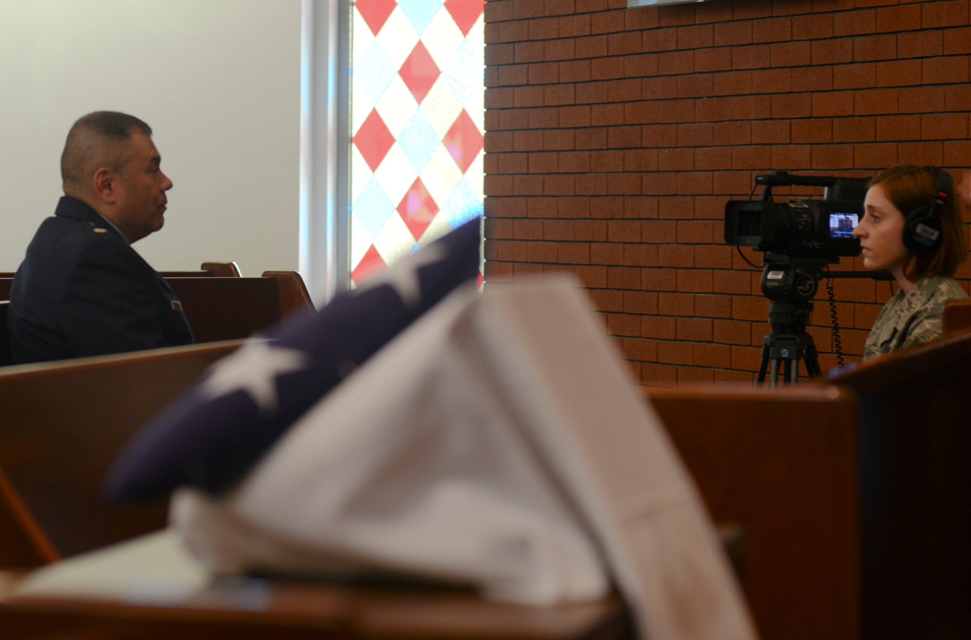 Airman Sieana Mackiewicz, American Forces Network Incirlik broadcast journalist, interviews Chaplain (Lt. Col.) Paul Castillo during the 9/11 memorial ceremony at the base chapel Sept. 11, 2014, Incirlik Air Base, Turkey. Castillo shared his personal account of Sept. 11, 2001. (U.S. Air Force photo by Staff Sgt. Eboni Reams/Released)