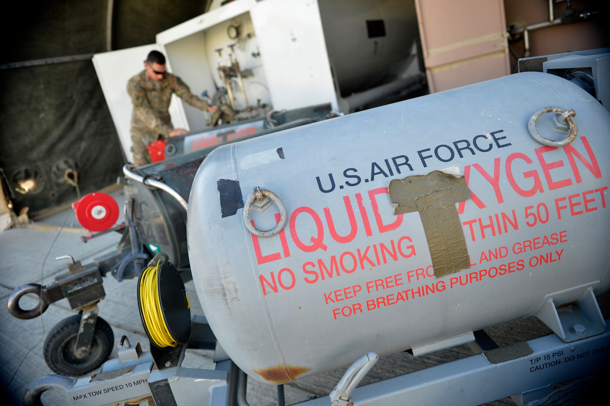 A U.S. Air Force Airman from the 455th Expeditionary Logistics Readiness Squadron refills liquid oxygen carts at Bagram Airfield, Afghanistan Sept. 5, 2014. Cryogenic technicians work with extremely cold substances that boil at subzero temperatures then evaporate into breathable air. The cryogenics technicians support 6,000 aircraft missions and issue more than 4,000 gallons of liquid oxygen per month. (U.S. Air Force photo by Staff Sgt. Evelyn Chavez/Released)