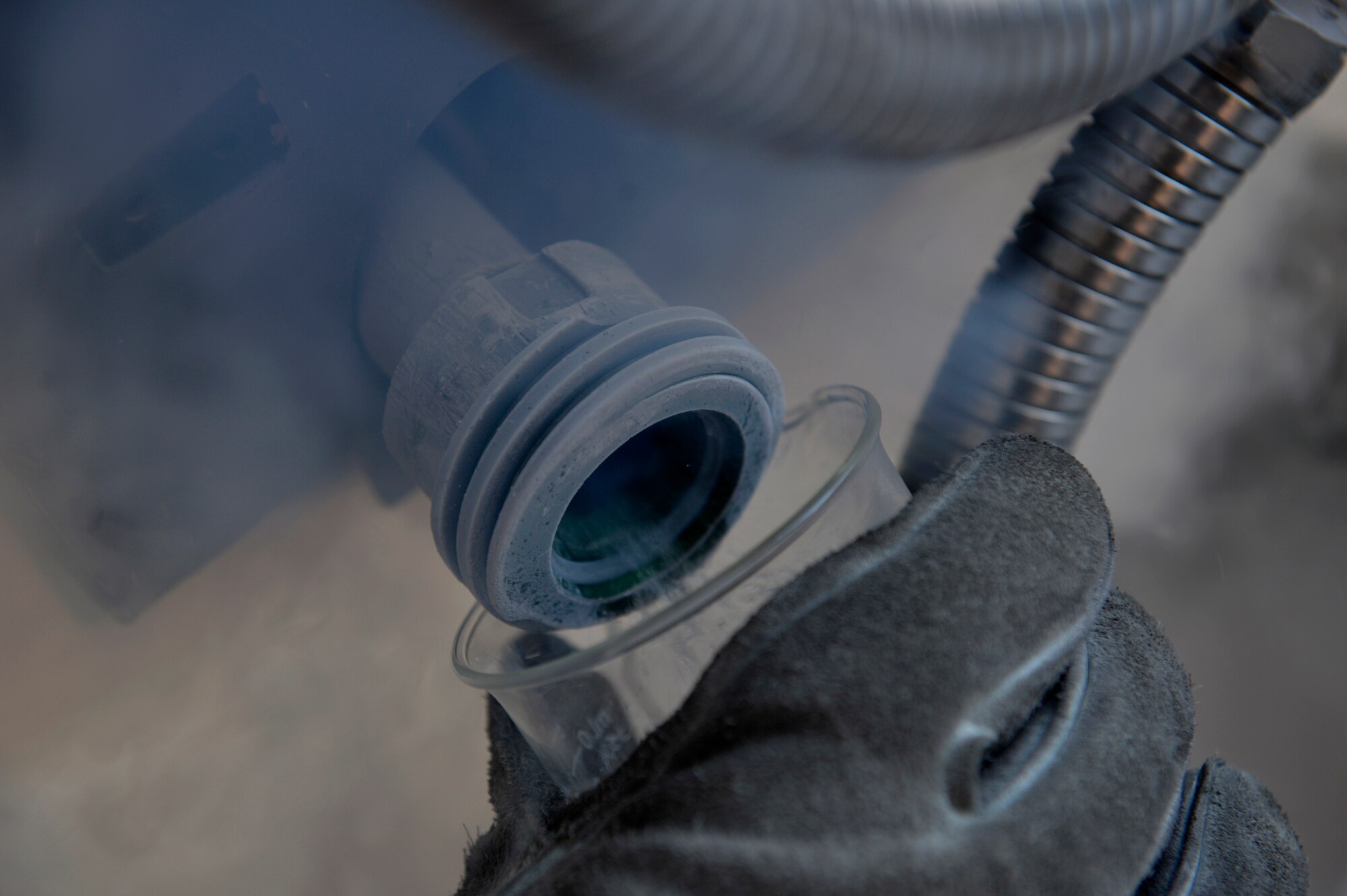 A U.S. Air Force Airman from the 455th Expeditionary Logistics Readiness Squadron collects a liquid oxygen sample at Bagram Airfield, Afghanistan Sept. 5, 2014. Cryogenic technicians work with extremely cold substances that boil at subzero temperatures, then evaporate into breathable air. The cryogenics technicians support 6,000 aircraft missions and provide more than 4,000 gallons of liquid oxygen per month. (U.S. Air Force photo by Staff Sgt. Evelyn Chavez/Released)