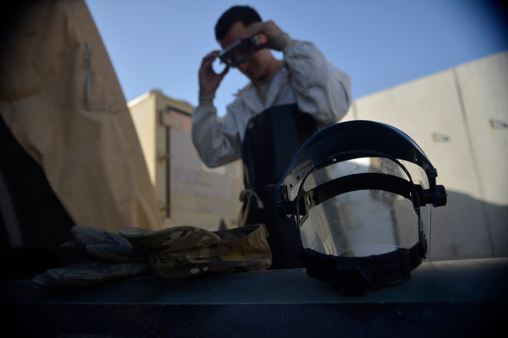 U.S. Air Force Staff Sgt. Taj Copeland, 455th Expeditionary Logistics Readiness Squadron  fuels distribution supervisor, adjusts protective gear before  refilling liquid oxygen carts at Bagram Airfield, Afghanistan Aug. 5, 2014.  Cryogenics Airmen provide sustainable air for aircrew to breathe at high altitudes.  Copeland is deployed from Nellis Air Force Base, Nev. and a native of Tampa, Fla. (U.S. Air Force photo by Staff Sgt. Evelyn Chavez/Released)