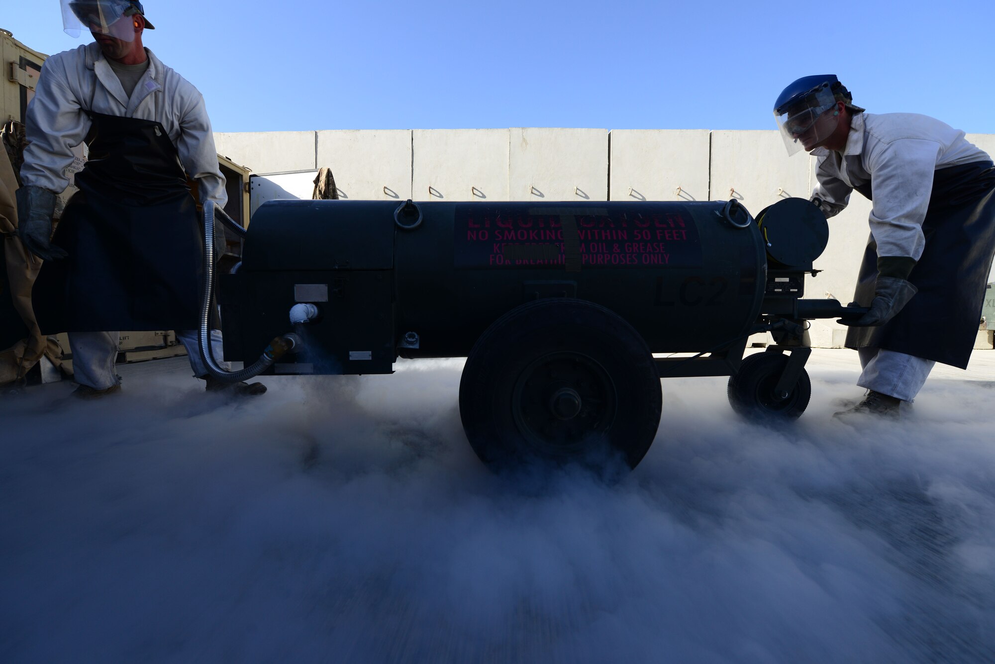 (From left) U.S. Air Force Staff Sgt. James Brumbaugh, 455th Expeditionary Logistics Readiness Squadron fuels cryogenics non-commisioned officer in-charge, and Staff Sgt. Taj Copeland 455 ELRS fuels distribution supervisor, move a liquid oxygen cart during a cryogenic refill at Bagram Airfield, Afghanistan Aug. 5, 2014. The cryogenics flight is responsible for providing more than 4,000 gallons of liquid oxygen per month to aircraft.  Brumbaugh is deployed from Davis-Monthan Air Force Base, Ariz. and a native of Clarkrange, Tenn.  Copeland is deployed from Nellis Air Force Base, Nev. and a native of Tampa, Fla. (U.S. Air Force photo by Staff Sgt. Evelyn Chavez/Released)