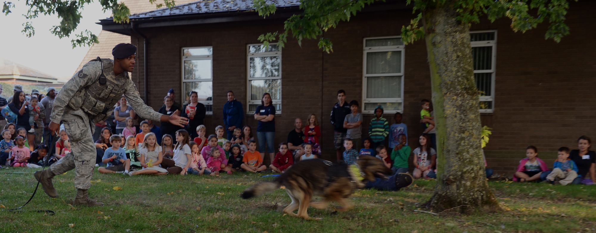 U.S. Air Force Staff Sgt. Matthew Clark, 100th Security Forces Squadron Military Working Dog handler from Dodge City, Kans., releases MWD Gina during a demonstration at a Hearts Apart event Sept. 10, 2014, at the chapel on RAF Mildenhall, England. The 100th Security Forces Squadron hosted the monthly event which helps bring the Team Mildenhall family closer together during times of separation. (U.S. Air Force photo/Airman 1st Class Preston Webb/Released)
