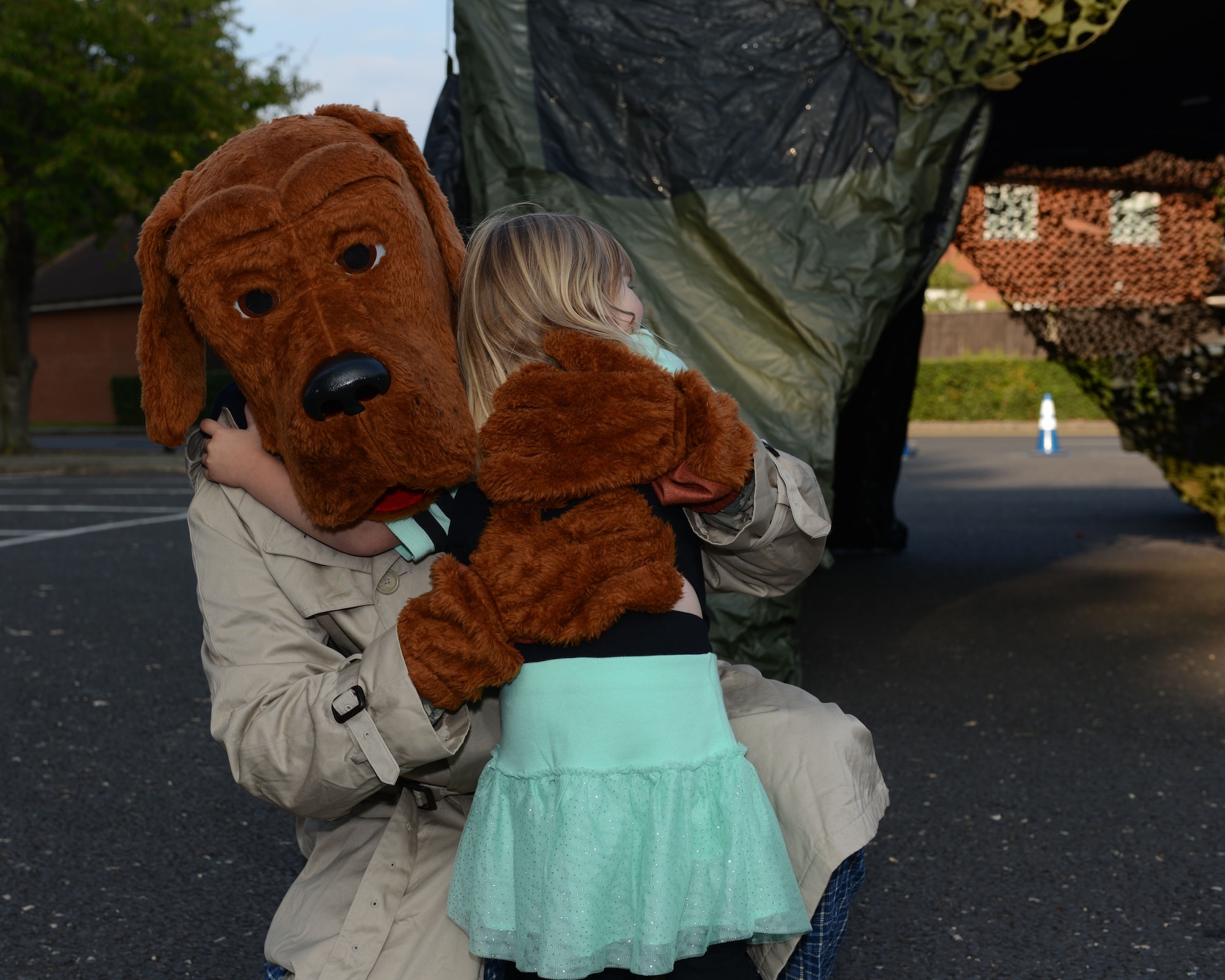 McGruff the Crime Dog hugs a Team Mildenhall child at a Hearts Apart event Sept. 10, 2014, at the chapel on RAF Mildenhall, England. The 100th Security Forces Squadron hosted the event which featured Military Working Dog demonstrations, photos with McGruff, face painting, bouncy castles and weapons displays. (U.S. Air Force photo/Airman 1st Class Preston Webb/Released)