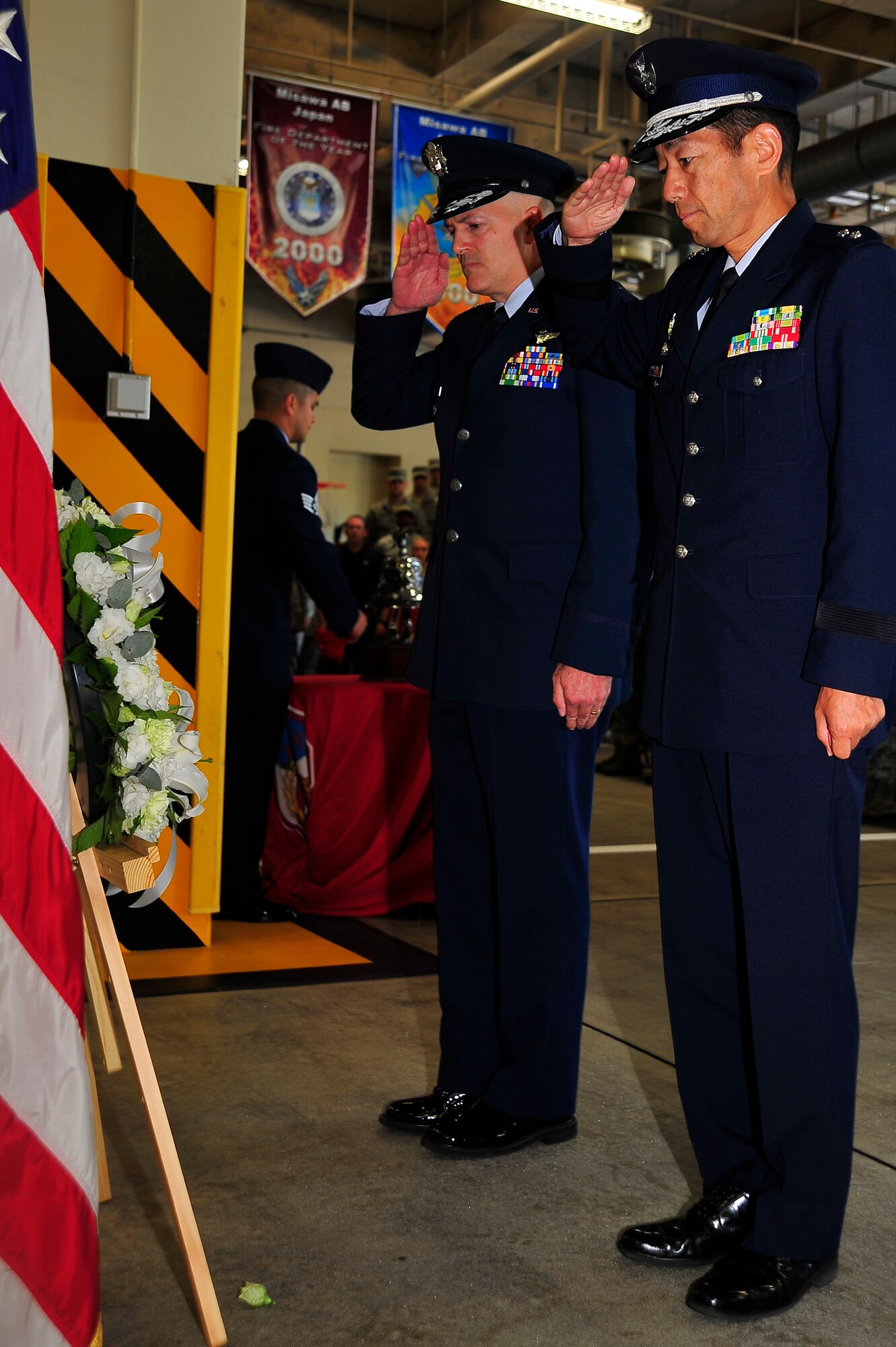 U.S. Air Force Col Andrew Hansen, 35th Fighter Wing vice commander, and Japanese Air Self-Defense Force Maj Gen Hirohide Inoue, 3rd Air Wing commander, salute a wreath as the ringing of the "Last Alarm" rang out during the 9/11 ceremony at Misawa Air Base, Japan, Sept. 11, 2014.  The wreath was a symbol in honor of the fallen having selflessly given their lives for the good of others. (U.S. Air Force photo/Tech. Sgt. April Quintanilla)