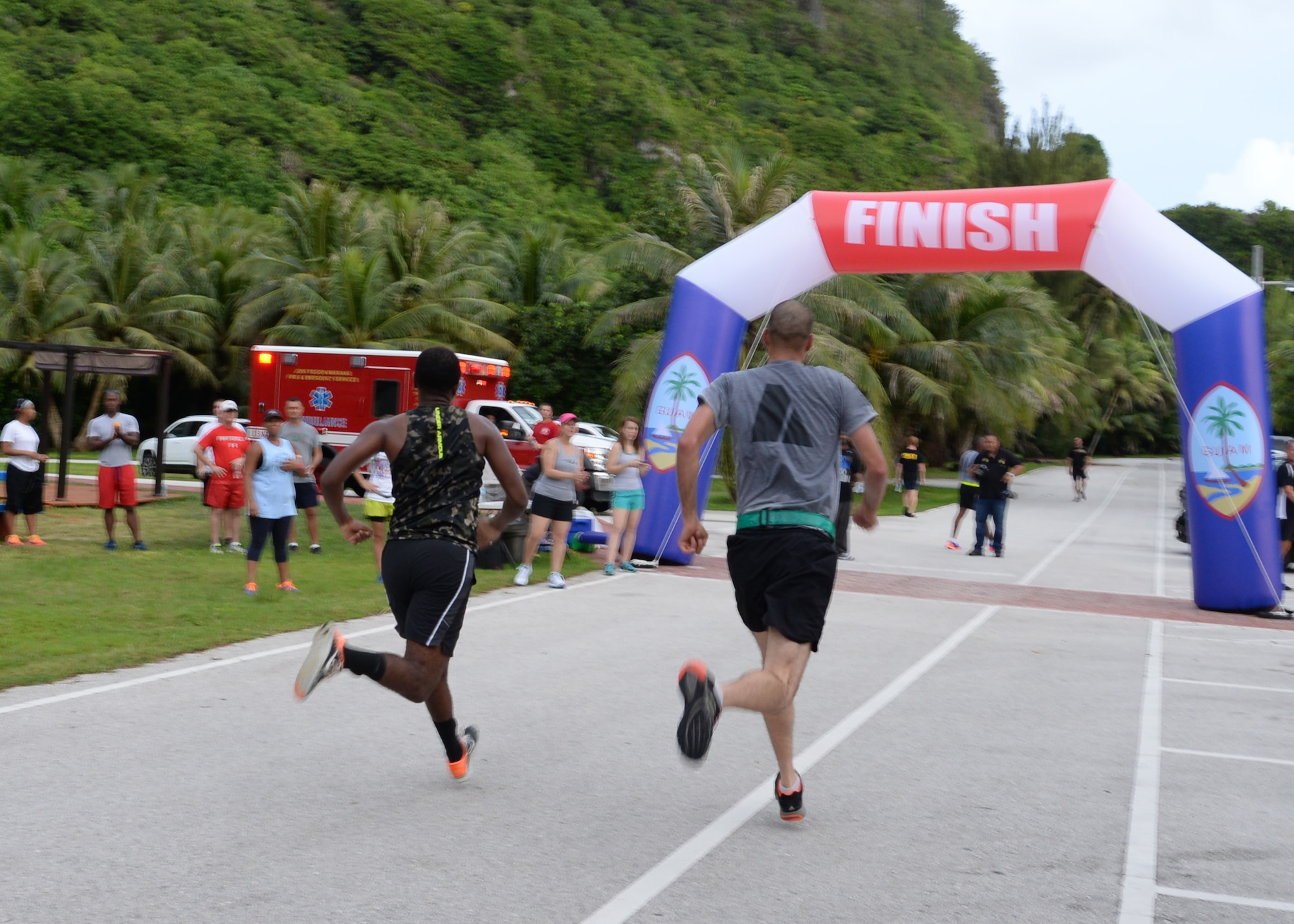 Two runners race toward the finish line during the Remembering our Heroes 5K at Tarague Beach Sep. 11, 2014, on Andersen Air Force Base, Guam. Approximately 200 runners participated in the 5k run and included individuals from all branches of service. (U.S. Air Force photo by Senior Airman Cierra Presentado/Released)