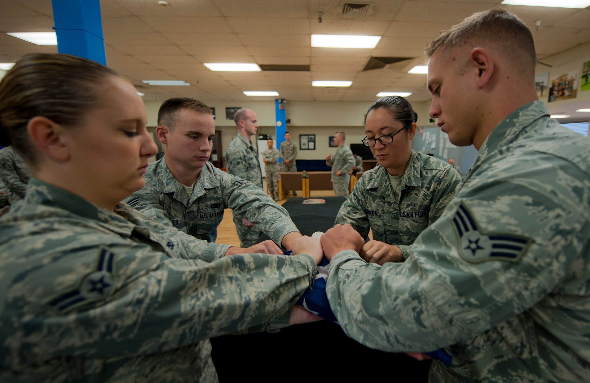 Airmen from the 366th Fighter Wing Base Honor Guard fold the American flag during the 366th FW Honor Guard all-call, Sept. 9, 2014, at Mountain Home Air Force Base, Idaho. The all-call is a way to promote the base Honor Guard program to interested Airmen, supervisors and Wing leadership. (U.S. Air Force photo by Staff. Sgt. Roy Lynch III/RELEASED)