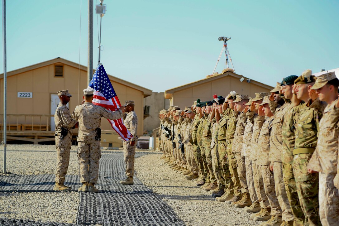Coalition forces salute the American flag during a 9/11 ceremony on Camp Leatherneck, Helmand province, Afghanistan, Sept. 11, 2014. The ceremony was held to commemorate the 13th anniversary of the 9/11 terrorist attacks.