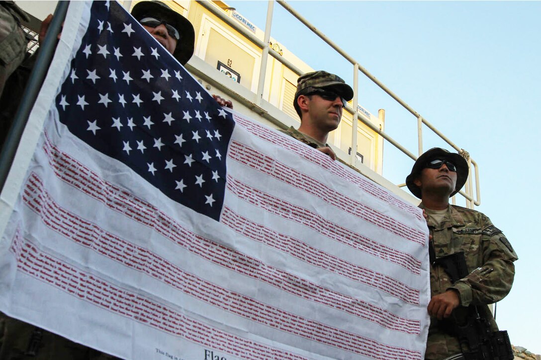 U.S. soldiers on Kandahar Airfield, Afghanistan, display a flag bearing the names of 9/11 first responders who lost their lives, Sept. 9, 2014. The soldiers are from the New York Army National Guard.
