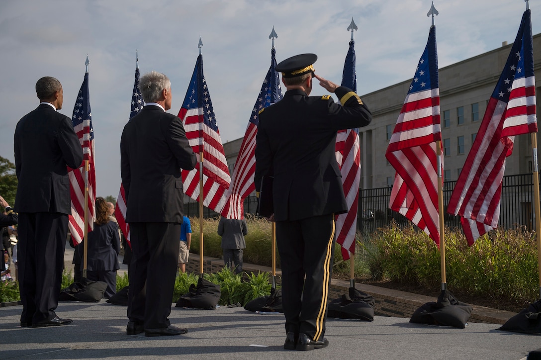 President Barack Obama, left, Defense Secretary Chuck Hagel, center, and Army Gen. Martin Dempsey, chairman of the Joint Chiefs, salute the American flag as the national anthem plays during a 9/11 ceremony at the Pentagon Memorial, Sept. 11, 2014.