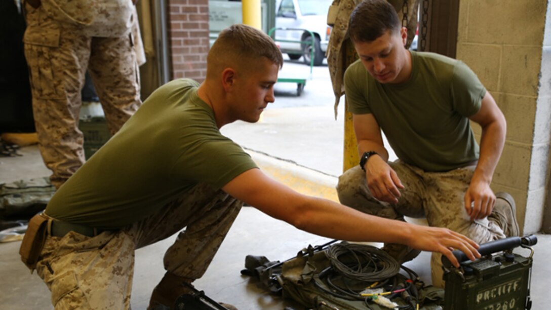 Lance Cpl. Alex Barney, left, ground radio repairman with the communications section of the Ground Combat Element Integrated Task Force, and Cpl. Christopher Del Valle, right, field radio operator, Communications Section, GCEITF, conduct a limited technical inspection of radio equipment at the 8th Marine Regiment communications building, Sept. 9, 2014. Marines received radios, antennas and other communications equipment. From October 2014 to July 2015, the GCEITF will conduct individual and collective level skills training in designated ground combat arms occupational specialties in order to facilitate the standards-based assessment of the physical performance of Marines in a simulated operating environment performing specific ground combat arms tasks. (Official Marine Corps photo by Cpl. Paul S. Martinez/Released)