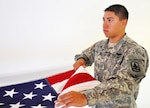 Army Pfc. Samuel Pineda, an infantryman and member of the Arizona Army National Guard’s Honor Guard, practices folding an American flag. Pineda assisted a neighbor’s family to safety when their residence caught fire Aug. 26, 2014. 