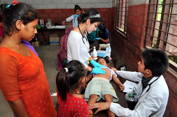 Dr. Seema Jilani, Project Hope pediatrician, and Dr. Richan Jirel, a local general medicine provider, examine a patient at a health services outreach site in Manahari, Nepal, Sept. 9, 2014, as part of Operation Pacific Angel-Nepal. PACANGEL helps cultivate common bonds and foster goodwill between the U.S., Nepal and regional nations by conducting multilateral humanitarian assistance and civil military operations. (U.S. Air Force photo by Staff Sgt. Melissa B. White)