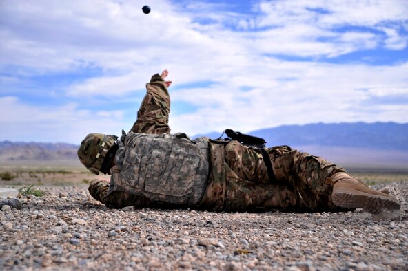 Staff Sgt. David Garcia throws an M-69 practice grenade during the last iteration of the M-67 fragmentation grenade training class Aug. 30, 2014, at Silver Flag Alpha, Nev. Students completed this course as part of their predeployment training in case of an event that requires use of grenades. Garcia is an evaluator with the 99th Security Forces Squadron. (U.S. Air Force photo/Airman 1st Class Christian Clausen)