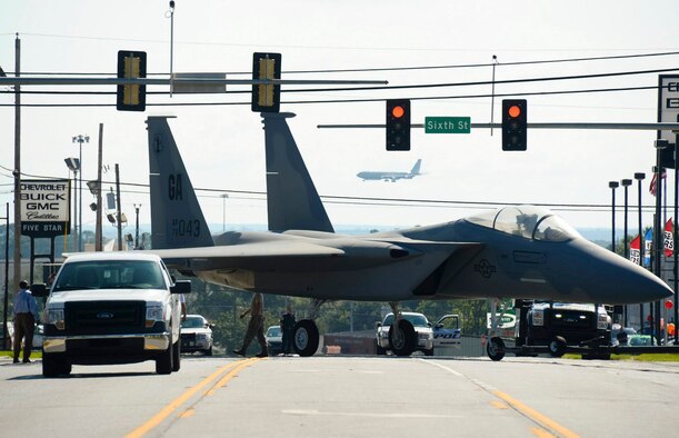 Airmen maneuver through traffic lights while towing an F-15 Eagle down Watson Boulevard Sept. 6, 2014, to the Warner Robins City Hall, Warner Robins, Ga. The aircraft was loaned to the city by the Georgia Air National Guard’s 116th Air Control Wing to serve as a static display for a new veteran’s memorial. The Airmen moving the aircraft are assigned to the 116th Maintenance Group. (U.S. Air National Guard photo/Tech. Sgt. Regina Young) 
