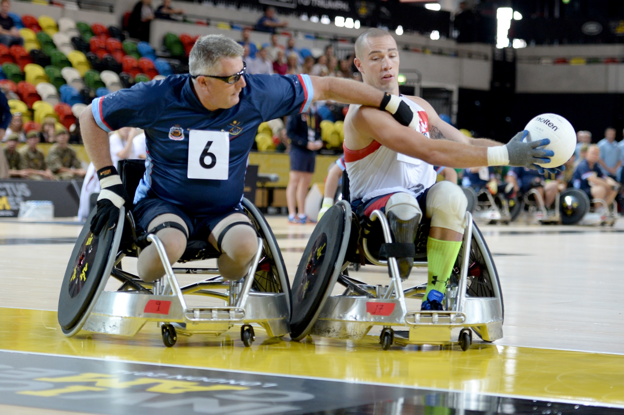 Army Sgt. Ryan McIntosh, representing the U.S., keeps the ball away from a defender during a wheelchair rugby match against Australia Sept. 12, 2014, at the 2014 Invictus Games in London. The U.S. won the match 14-4. Invictus Games is an international competition that brings together wounded, injured and ill service members in the spirit of friendly athletic competition. American Soldiers, Sailors, Airmen and Marines are representing the U.S. in the competition which is taking place Sept. 10-14. (U.S. Navy photo/Mass Communication Specialist 2nd Class Joshua D. Sheppard)