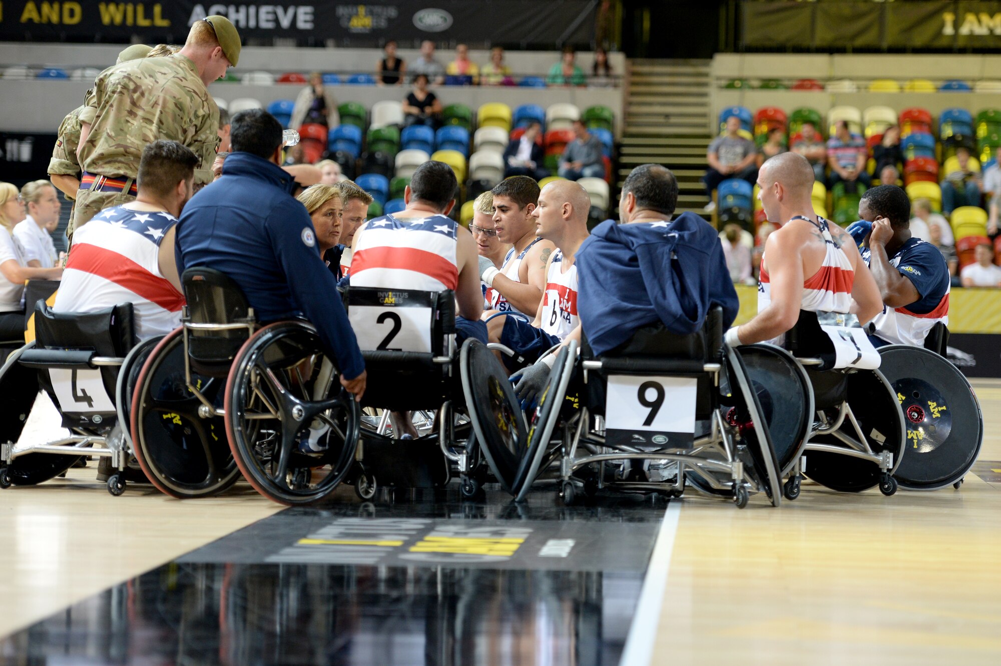 Members of the U.S. wheelchair rugby team are coached during a timeout of a wheelchair rugby match against Australia Sept. 12, 2014, at the 2014 Invictus Games in London. The U.S. won the match 14-4. Invictus Games is an international competition that brings together wounded, injured and ill service members in the spirit of friendly athletic competition. American Soldiers, Sailors, Airmen and Marines are representing the U.S. in the competition which is taking place Sept. 10-14. (U.S. Navy photo/Mass Communication Specialist 2nd Class Joshua D. Sheppard)