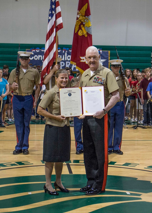 Brig. Gen. Helen G. Pratt (left), commanding general of Force Headquarters Group, and Lt. Gen. Richard Mills, commander of Marine Forces Reserve, hold Pratt’s certificate of promotion after her promotion ceremony at Glenridge Middle School Sept. 5, 2014. Pratt was promoted in front of the students, teachers and fellow staff members of the school, where she was a guidance counselor prior to taking command.