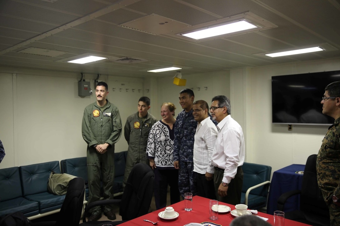 Marines and Sailors with ties to El Salvador pose for a photo with distinguished visitors during a key leader engagement (KLE) with Salvadoran officials aboard the future amphibious assault ship USS America (LHA 6), Sept. 8, 2014. The KLE consisted of a tour, a formal lunch and a leadership conference discussing the importance of partnership and cooperation between the U.S Naval forces and the Nation of El Salvador. Marines and Sailors with Special Purpose Marine Air Ground task Force South are embarked aboard America in support of her maiden transit, “America Visits the Americas.” The transit demonstrates the unparalleled capabilities that the Navy-Marine Corps team brings to our Nation and partners. (U.S. Marine Corps photo by 1st Lt. Joshua Pena / Released)