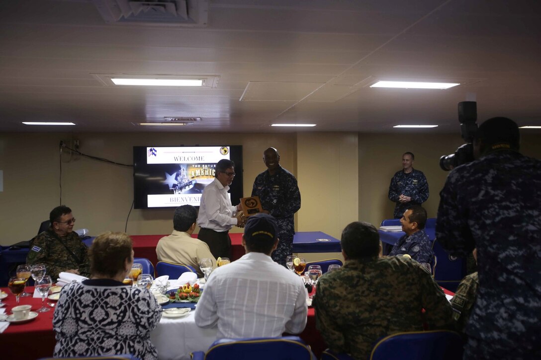 Rear Adm. Frank L. Ponds, commander of Expeditionary Strike Group 3, presents a plaque to a Salvadoran official during a leadership conference aboard the future amphibious assault ship USS America (LHA 6), Sept. 8, 2014. The leadership conference was part of a key leader engagement with the ship’s command and Salvadoran officials focusing on the importance of partnership and cooperation between our two nations. Special Purpose Marine Air Ground Task Force South is embarked aboard America in support of her maiden transit, "America Visits the Americas." The transit demonstrates the capabilities the Navy-Marine Corps team brings to our nation and partners. (U.S. Marine Corps photo by 1st Lt. Joshua Pena / Released)