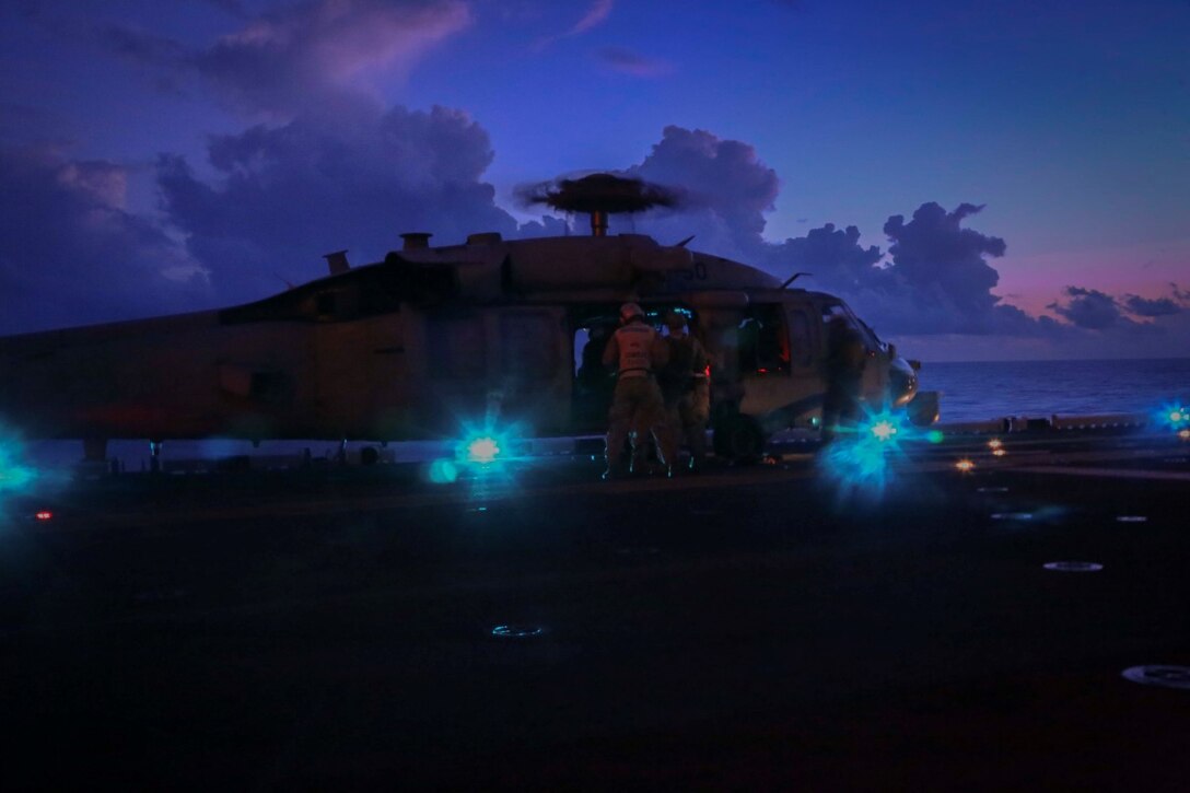 Marine snipers with the Reconnaissance Detachment, 11th Marine Expeditionary Unit, set up their rifle rigging system in an MH-60S Seahawk with Helicopter Sea Combat Squadron 23 (HSC-23) on the flight deck of the USS Makin Island in preparation for an aerial gun shoot Sept. 11, 2014. The 11th MEU and Makin Island Amphibious Ready Group are deployed to U.S. 7th Fleet area of operations as a sea-based, expeditionary crisis response force capable of conducting amphibious missions across the full range of military operations.  (U.S. Marine Corps photo by Cpl. Laura Y. Raga/Released)