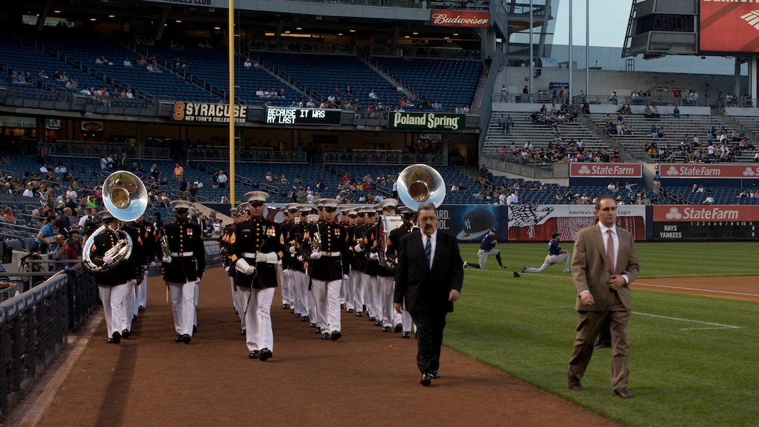 Led by Gunnery Sgt. Mark G. Bender, a drum major, the Quantico Marine Band marches onto Yankee Stadium Sept. 11, 2014, at New York City. The band went to the stadium to perform the National Anthem in respect to the people, who lost their lives 13 years ago during the 9/11 attacks on the World Trade Center. 