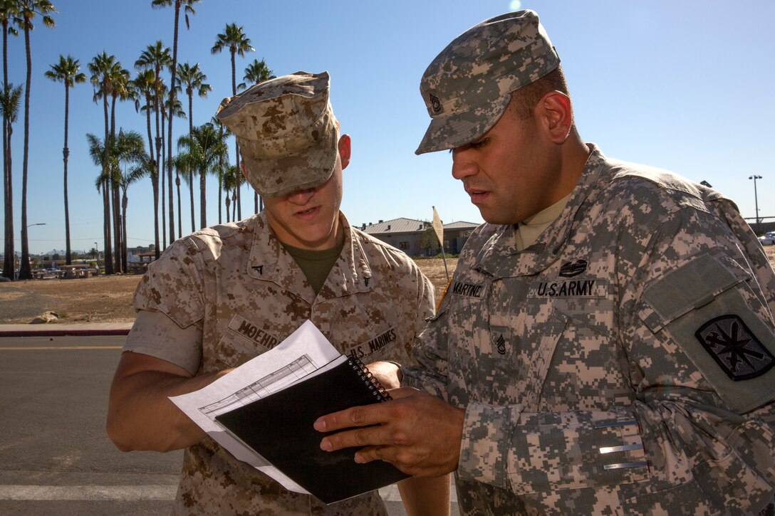 Army Sgt. 1st Class John Martinez, the oncoming course chief with 343rd Training Squadron out of Lackland Air Force Base, Texas, answers questions from Lance Cpl. Preston Moehring, a military police officer with Provost Marshal’s Office at Marine Corps Base Camp Pendleton, Calif., during the Traffic Collision Investigation Course aboard Marine Corps Air Station Miramar, Calif., Sept. 11. The course is designed to teach students proper procedures to use while investigating car accidents.