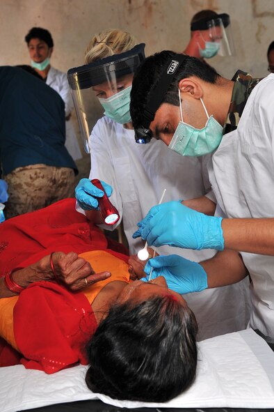 Nepalese Army Sgt. Santosh Panta, dentist, and Royal Australian Air Force Sgt. Kerry Sears, Operation Pacific Angel-Nepal dental assistant, examine a patient at a health services outreach location in Shaktikhor, Nepal, Sept. 12, 2014. PACANGEL helps cultivate common bonds and foster goodwill between the U.S., Nepal and regional nations by conducting multilateral humanitarian assistance and civil military operations. (U.S. Air Force photo by Staff Sgt. Melissa B. White/Released)