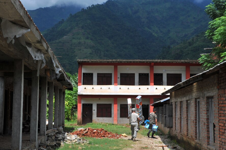 U.S. Air Force Senior Airman Marc Cotledge, Operation Pacific Angel-Nepal electrician, and a Nepalese Army Soldier move equipment at an engineering civic action project site in Shaktikhor, Nepal, Sept. 8, 2014. PACANGEL supports U.S. Pacific Command’s capacity-building efforts by partnering with other governments, non-governmental agencies and multilateral militaries in the respective region to provide medical, dental, optometry and engineering assistance to their citizens. (U.S. Air Force photo by Staff Sgt. Melissa B. White/Released)