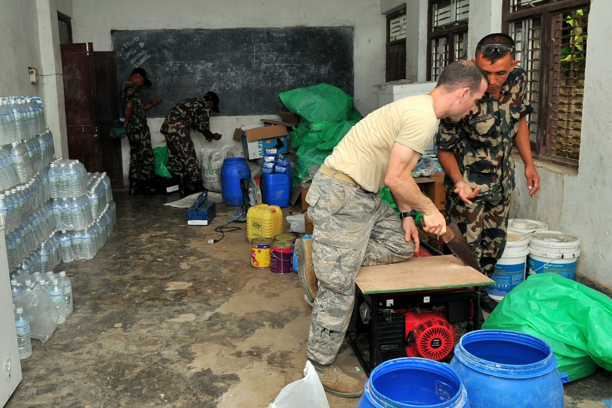 U.S. Air Force Staff Sgt. Jared Caspari, Operation Pacific Angel-Nepal structures journeyman, and Nepalese Army Soldiers cut wood to repair a school at an engineering civic action project site in Shaktikhor, Nepal, Sept. 10, 2014. PACANGEL supports U.S. Pacific Command’s capacity-building efforts by partnering with other governments, non-governmental agencies and multilateral militaries in the respective region to provide medical, dental, optometry and engineering assistance to their citizens. (U.S. Air Force photo by Staff Sgt. Melissa B. White/Released) 