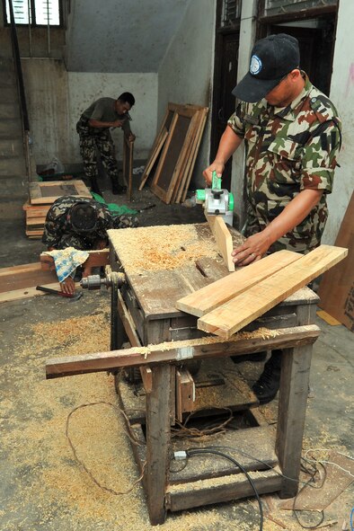 Nepalese Army Soldiers craft window shutters for a school at an Operation Pacific Angel-Nepal Engineering Civic Action Project site in Shaktikhor, Nepal, Sept. 10, 2014. PACANGEL helps cultivate common bonds and foster goodwill between the U.S., Nepal and regional nations by conducting multilateral humanitarian assistance and civil military operations. (U.S. Air Force photo by Staff Sgt. Melissa B. White/Released)