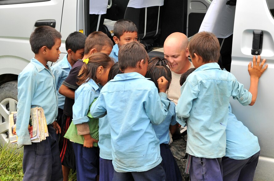 U.S. Air Force Tech. Sgt. Steven Emerson, Operation Pacific Angel-Nepal engineer planner, interacts with local schoolchildren at an engineering civic action project site in Shaktikhor, Nepal, Sept. 10, 2014. PACANGEL supports U.S. Pacific Command’s capacity-building efforts by partnering with other governments, non-governmental agencies and multilateral militaries in the respective region to provide medical, dental, optometry and engineering assistance to their citizens. (U.S. Air Force photo by Staff Sgt. Melissa B. White/Released)