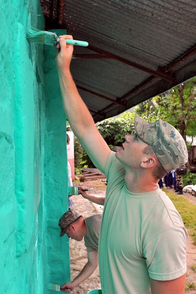 U.S. Air Force Staff Sgt. Christopher Munrow, Operation Pacific Angel-Nepal plumber, paints the outside of a school as part of an engineering civic action project in Shaktikhor, Nepal, Sept. 11, 2014. PACANGEL helps cultivate common bonds and foster goodwill between the U.S., Nepal and regional nations by conducting multilateral humanitarian assistance and civil military operations. (U.S. Air Force photo by Staff Sgt. Melissa B. White/Released)