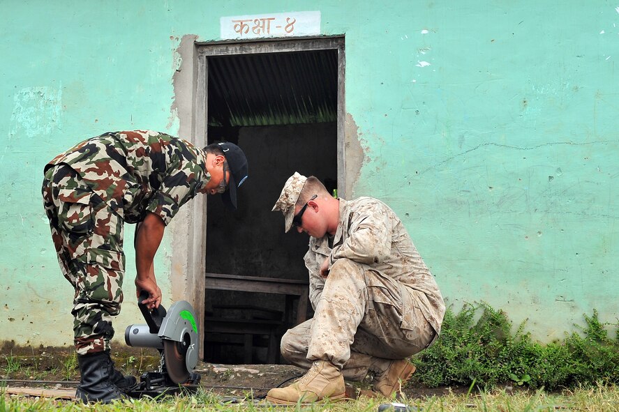 U.S. Marine Corps Cpl. Kaleb Bill, Operation Pacific Angel-Nepal combat engineer, helps Nepalese Army Cpl. Dal Ale, mason, cut rebar to build steps as part of an engineering civic action project in Shaktikhor, Nepal, Sept. 11, 2014. PACANGEL helps cultivate common bonds and foster goodwill between the U.S., Nepal and regional nations by conducting multilateral humanitarian assistance and civil military operations. (U.S. Air Force photo by Staff Sgt. Melissa B. White/Released)