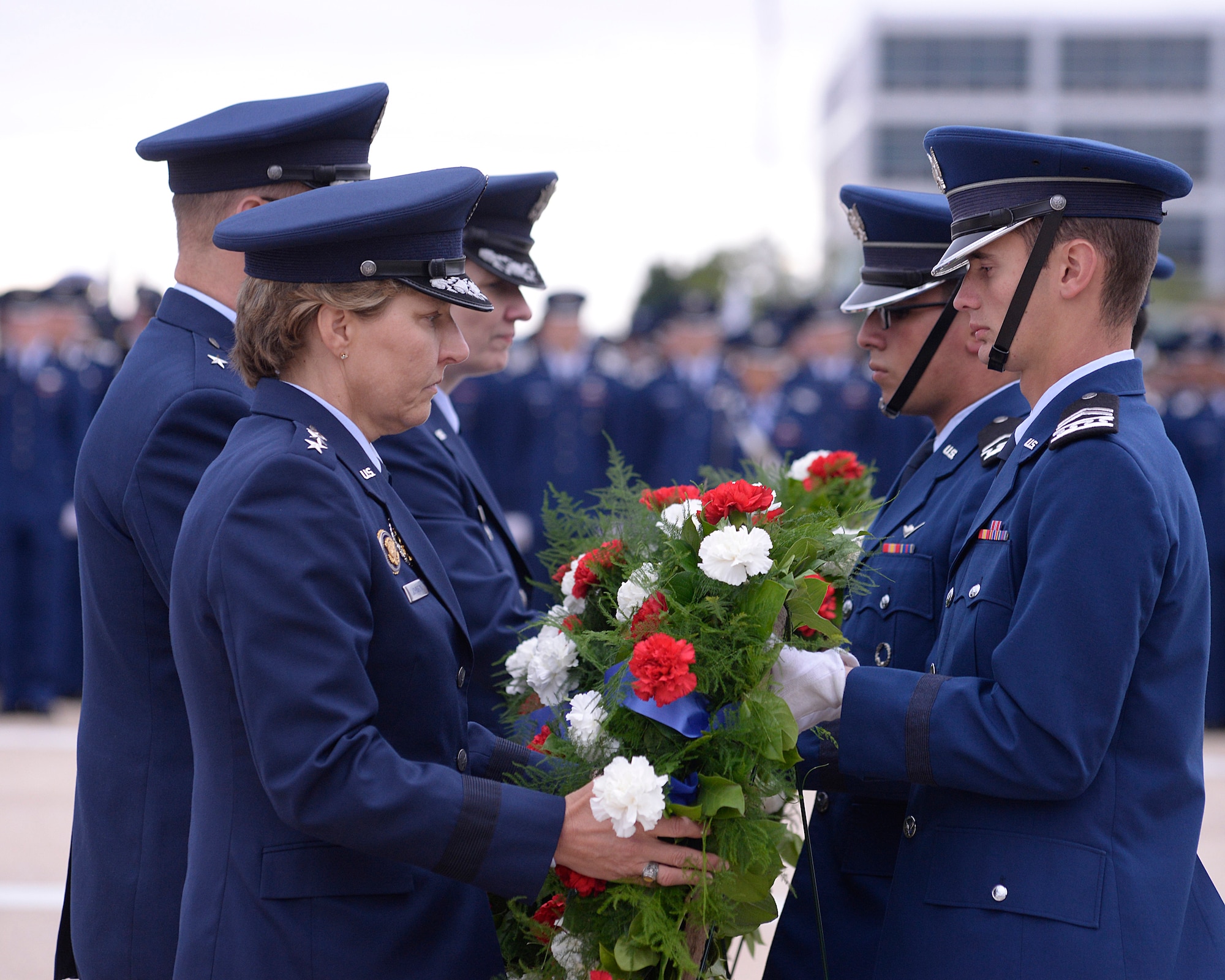 Cadets hand three wreaths to (from left to right) Academy Superintendent Lt. Gen. Michelle D. Johnson, Commandant of Cadets Brig. Gen. Stephen Williams and Vice Dean of the Faculty Col. Kathleen Harrington during the 9/11 Remembrance Ceremony here Sept. 11. (U.S. Air Force photo/Mike Kaplan)