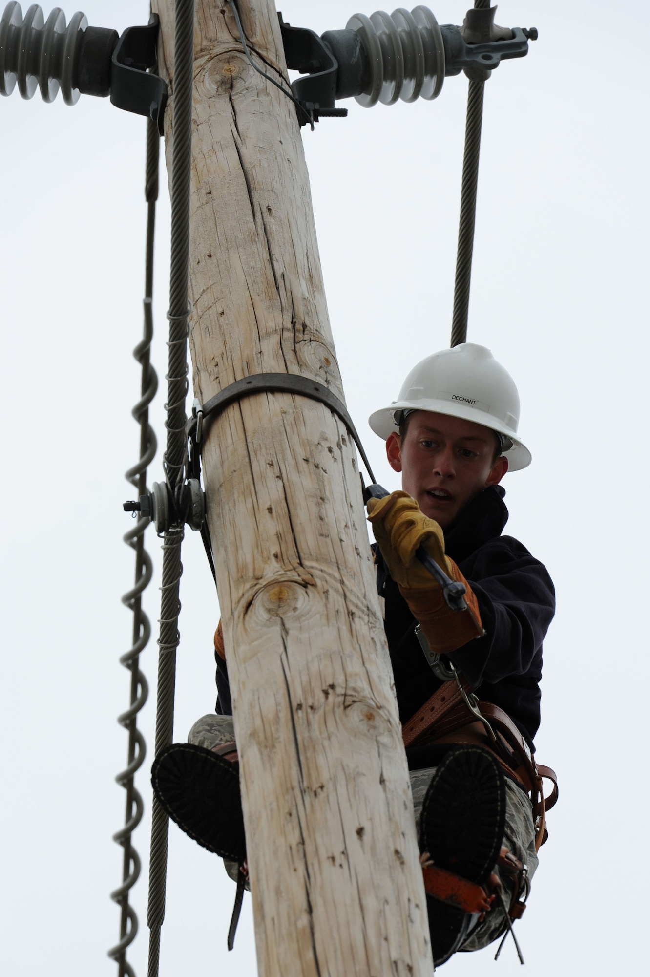 Airman 1st Class Daniel Dechant, 28th Civil Engineer Squadron electrical systems journeyman, tightens conductors on a utility pole during routine maintenance at Ellsworth Air Force Base, S.D., Sept. 9, 2014. Electrical systems Airmen perform annual preventive maintenance on utility poles which ensures that, when it snows, the weight of the snow has a lesser chance of tripping the circuit and cutting power to portions of the base. (U.S. Air Force photo by Senior Airman Hailey R. Staker/Released)