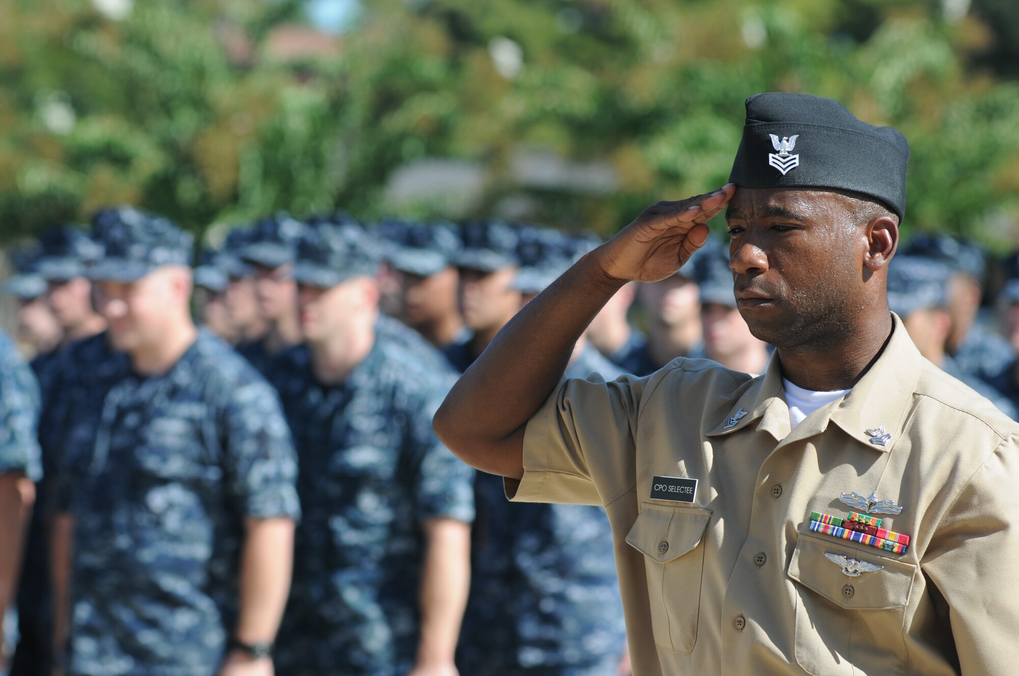 Petty Officer 1st Class Sedric Jones, Center for Naval Aviation Technical Training Unit Keesler, renders a salute as a worn U.S. flag burns, which is the proper procedure for retiring a U.S. Flag, during a remembrance ceremony Sept. 11, 2014, Keesler Air Force Base, Miss.  The ceremony also honored those who lost their lives during the 9/11 attacks. (U.S. Air Force photo by Kemberly Groue)