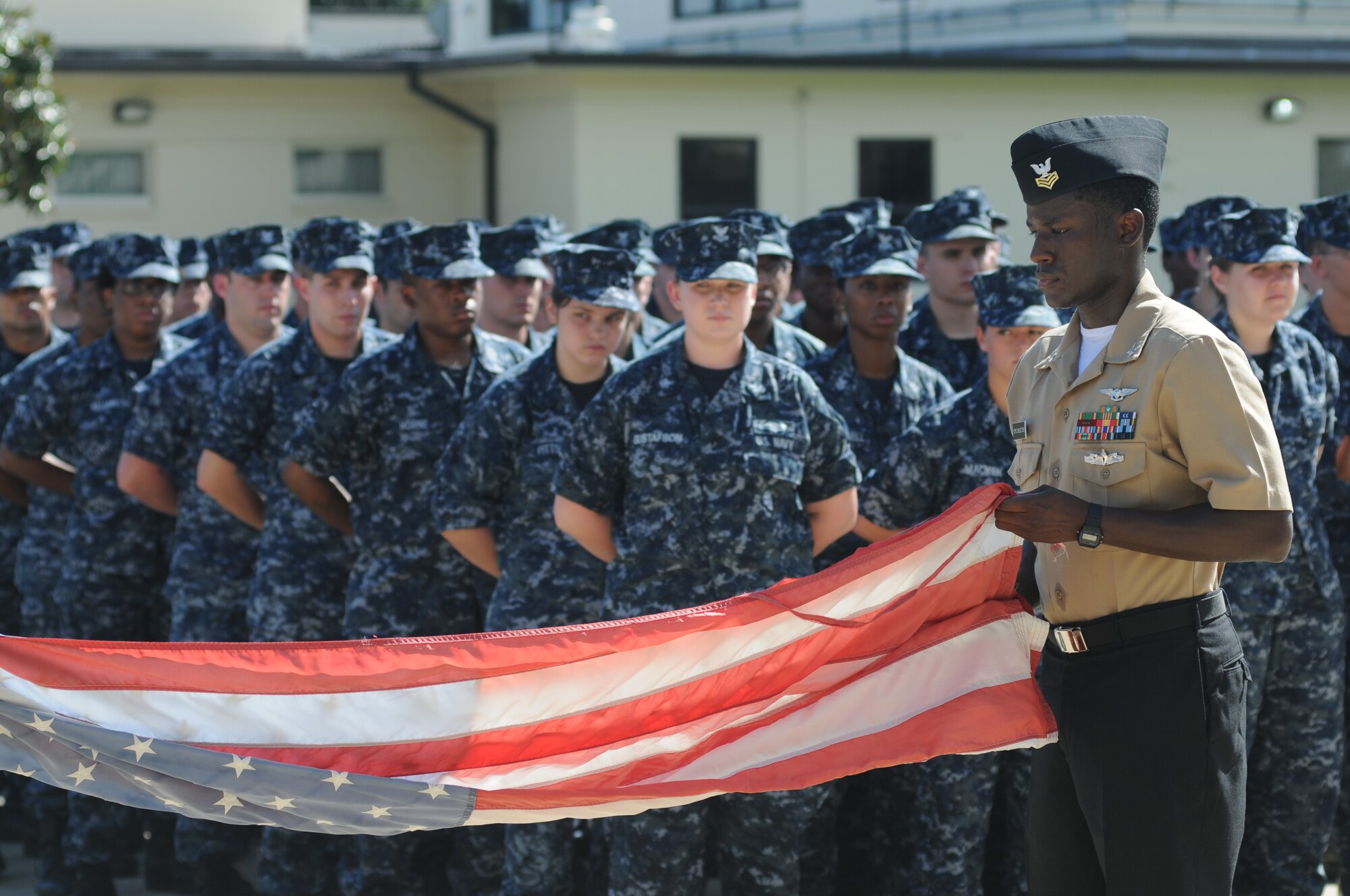 Petty Officer 1st Class Quintron Perry, Center for Naval Aviation Technical Training Unit Keesler, holds a worn U.S. flag to be retired during a remembrance ceremony Sept. 11, 2014 , Keesler Air Force Base, Miss.  The ceremony also honored those who lost their lives during the 9/11 attacks. (U.S. Air Force photo by Kemberly Groue)