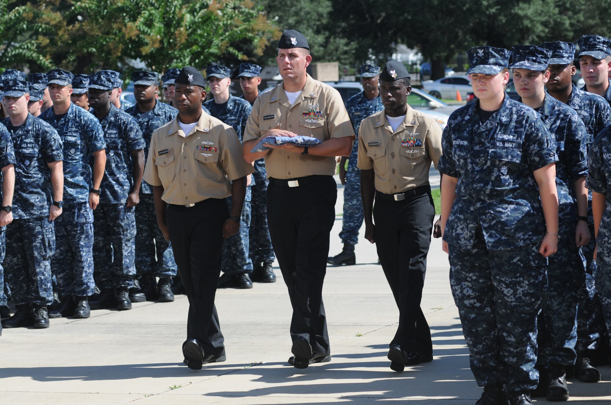 Petty Officers 1st Class Sedric Jones, Nathan Bizzle and Quintron Perry, Center for Naval Aviation Technical Training Unit Keesler, carry a worn U.S. flag to be retired during a remembrance ceremony Sept. 11, 2014 , Keesler Air Force Base, Miss.  The ceremony also honored those who lost their lives during the 9/11 attacks. (U.S. Air Force photo by Kemberly Groue)