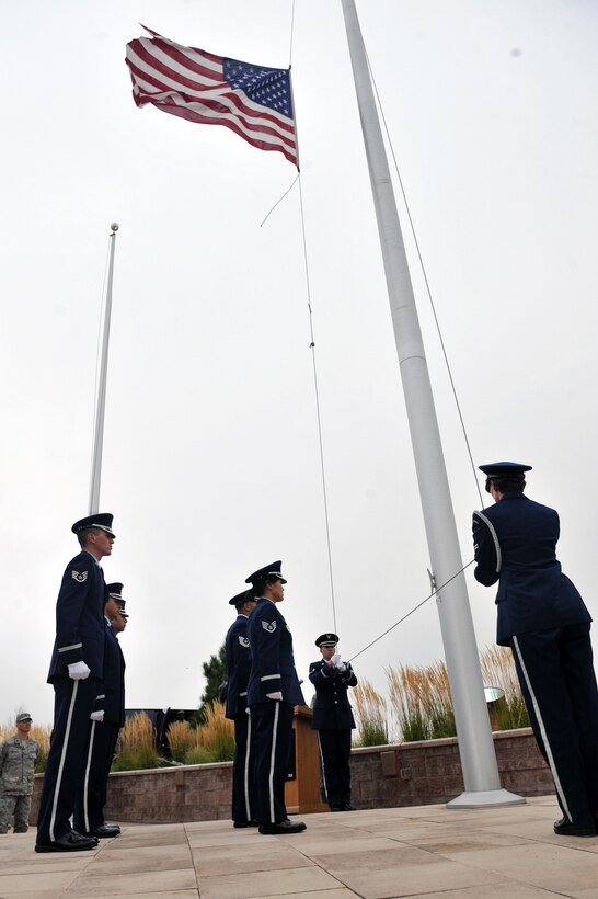 The Mile High Honor Guard lowers the flag during the Patriot Day retreat ceremony Sept. 11, 2014, on Buckley Air Force Base, Colo. Patriot Day is the national day of service and remembrance, in memory of the thousands killed on U.S. soil in the 9/11 attacks. (U.S. Air Force Photo by Airman Emily E. Amyotte/Released)