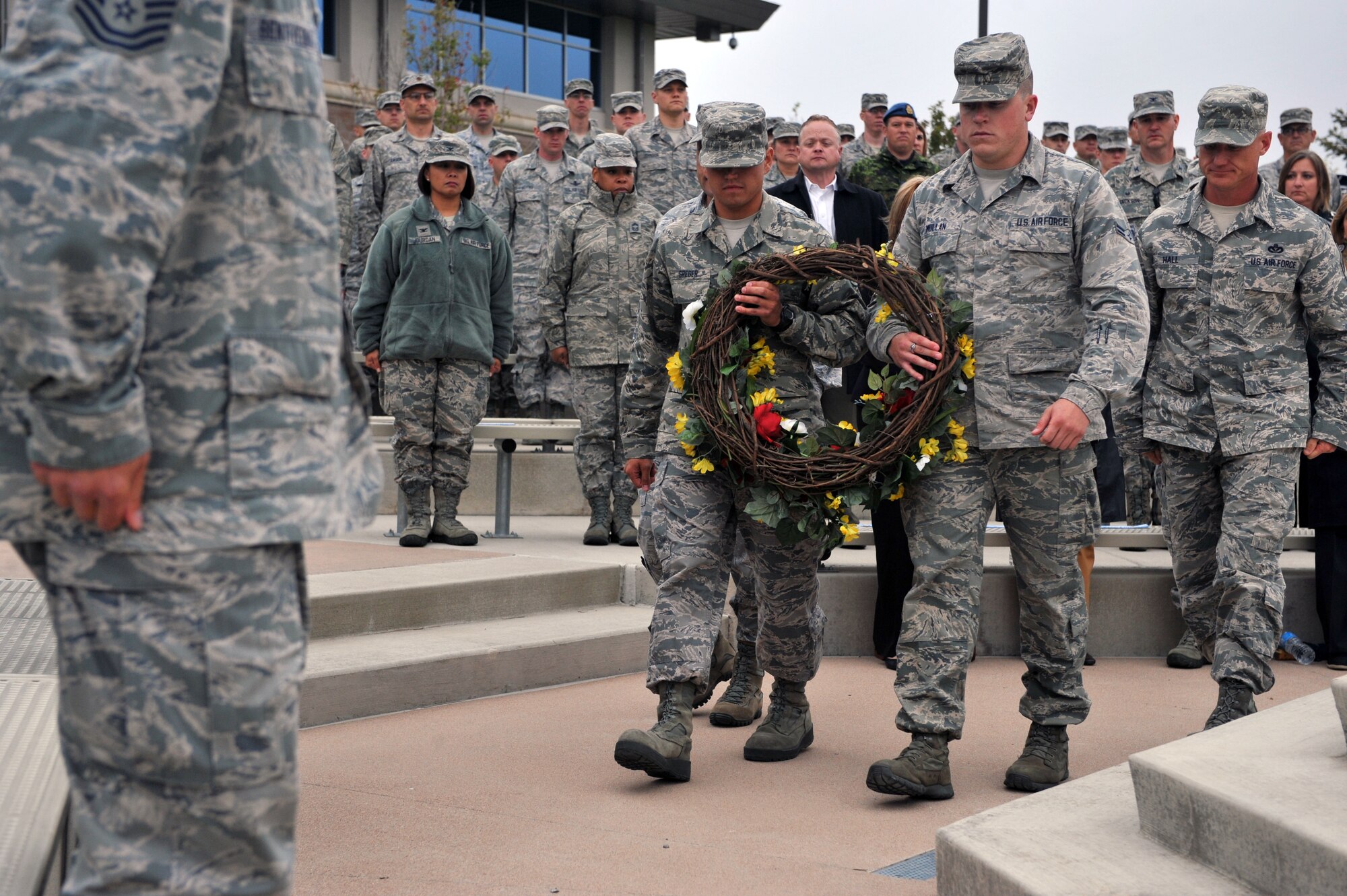 Airman 1st Class Ryan Mullen, 460th Operations Group administrator, right, and Senior Airman Matthew Greger, 2nd Space Warning Squadron, left, present the wreath during the Patriot Day retreat ceremony Sept. 11, 2014, on Buckley Air Force Base, Colo. Patriot Day is the national day of service and remembrance, in memory of the thousands killed on U.S. soil in the 9/11 attacks. (U.S. Air Force Photo by Airman Emily E. Amyotte/Released)