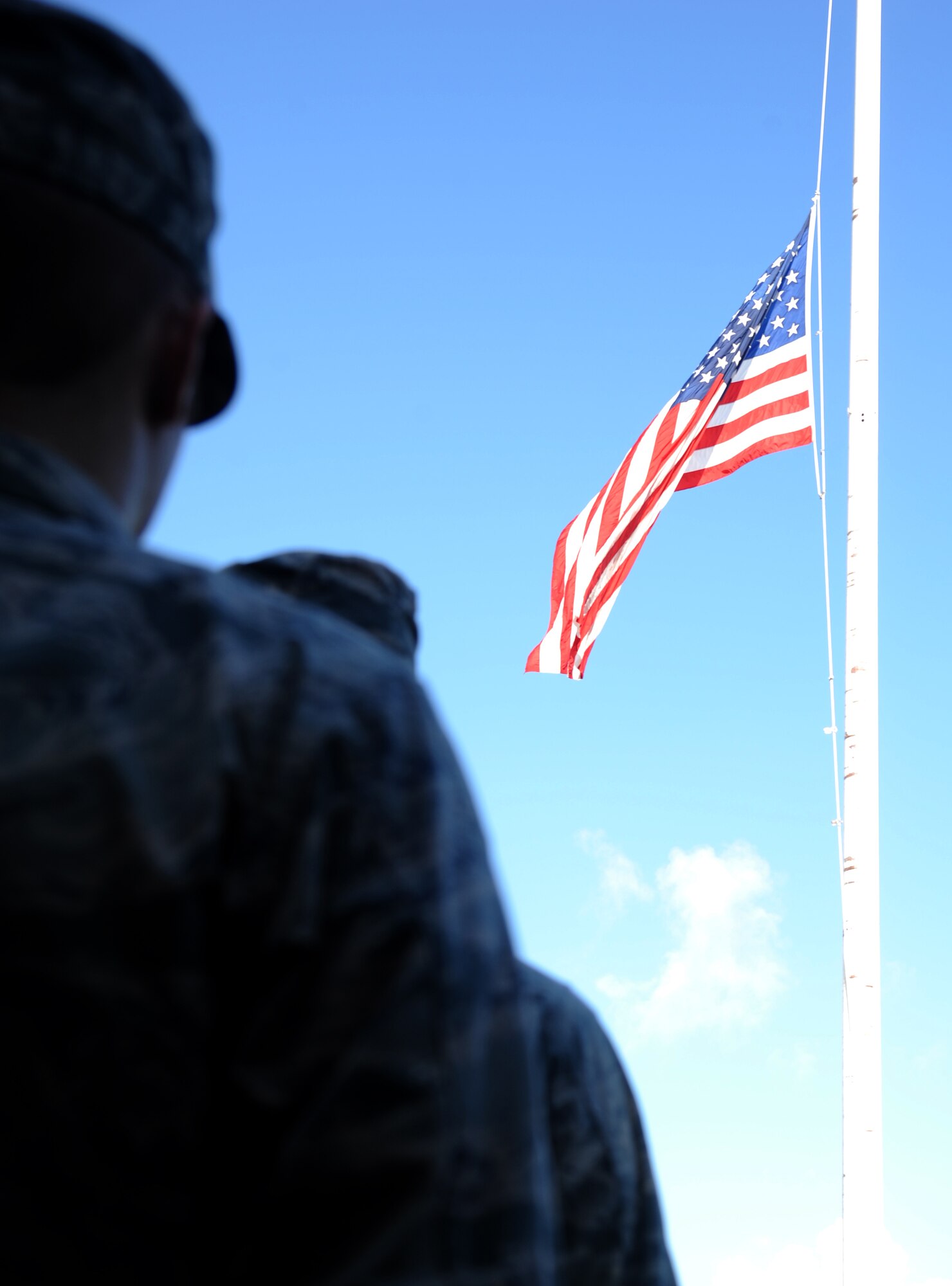 Keesler personnel observe a moment of silence as the flag flies at half-staff during a remembrance ceremony Sept. 11, 2014, Keesler Air Force Base, Miss. The ceremony honored those who lost their lives during the 9/11 attacks.  (U.S. Air Force photo by Kemberly Groue)