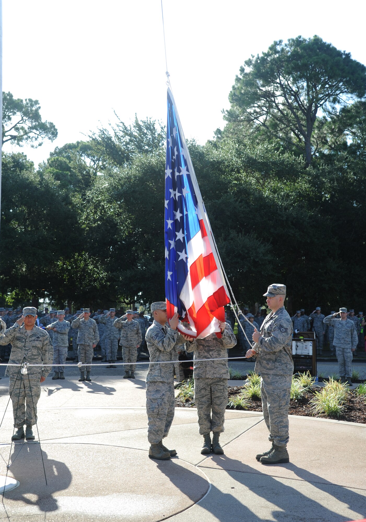 Keesler personnel render a salute as members of the 333rd Training Squadron prepare to raise the flag so that it can then be lowered to half-staff during a remembrance ceremony Sept. 11, 2014, Keesler Air Force Base, Miss. The ceremony honored those who lost their lives during the 9/11 attacks.  (U.S. Air Force photo by Kemberly Groue)