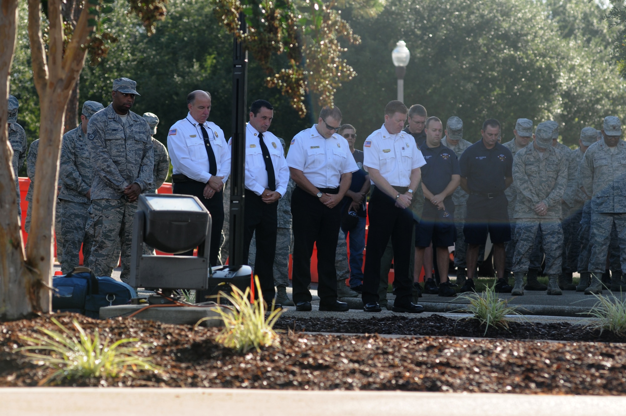 Firefighters from Biloxi, Miss., and Keesler Air Force Base, Miss., stand among Keesler personnel as they observe a moment of silence during a remembrance ceremony Sept. 11, 2014, Keesler Air Force Base, Miss. The ceremony honored those who lost their lives during the 9/11 attacks.  (U.S. Air Force photo by Kemberly Groue)