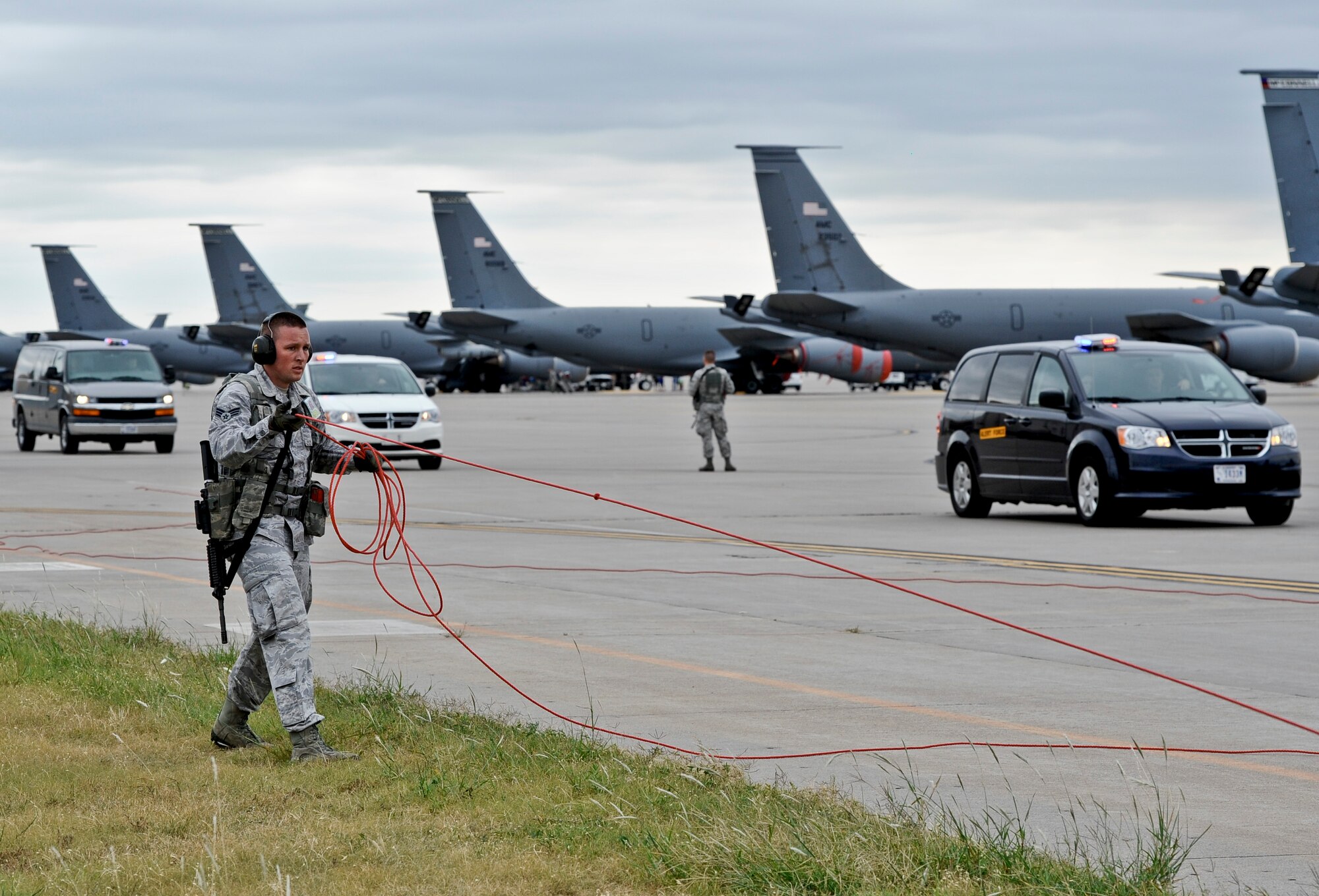 Senior Airman Justine Robinette, 22nd Security Forces Squadron entry controller, clears space on the runway, Sept. 10, 2014, at McConnell Air Force Base, Kan. Vans carrying aircrew members rushed to their designated aircraft in response to a training exercise. (U.S. Air Force photo/Airman 1st Class John Linzmeier)  